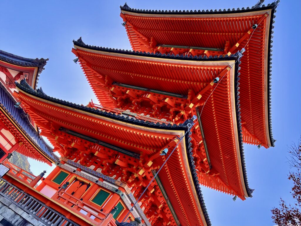 朱色の三重塔と紅葉が重なり合う清水寺の風景